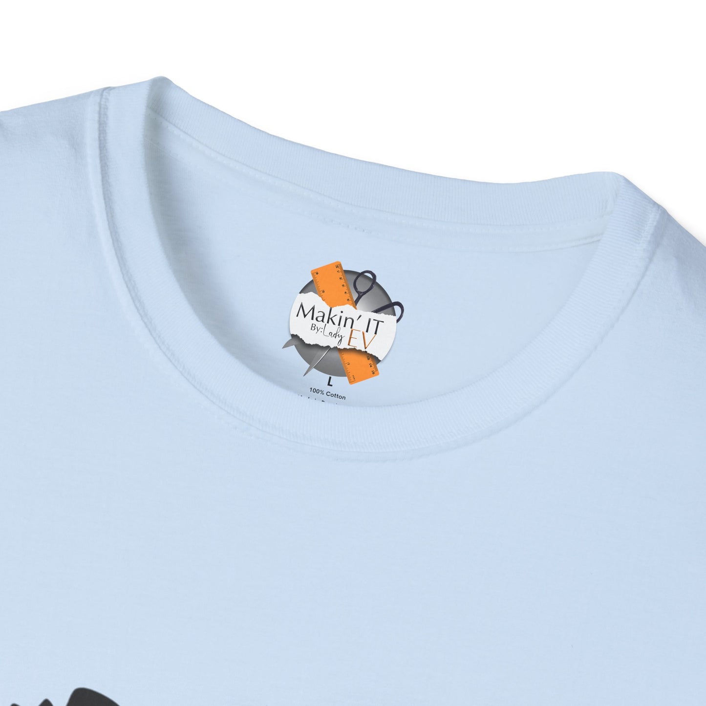 Close-up of light blue Halloween t-shirt neckline with Makin’ It By Lady Ev custom tag and ghost beanie print.