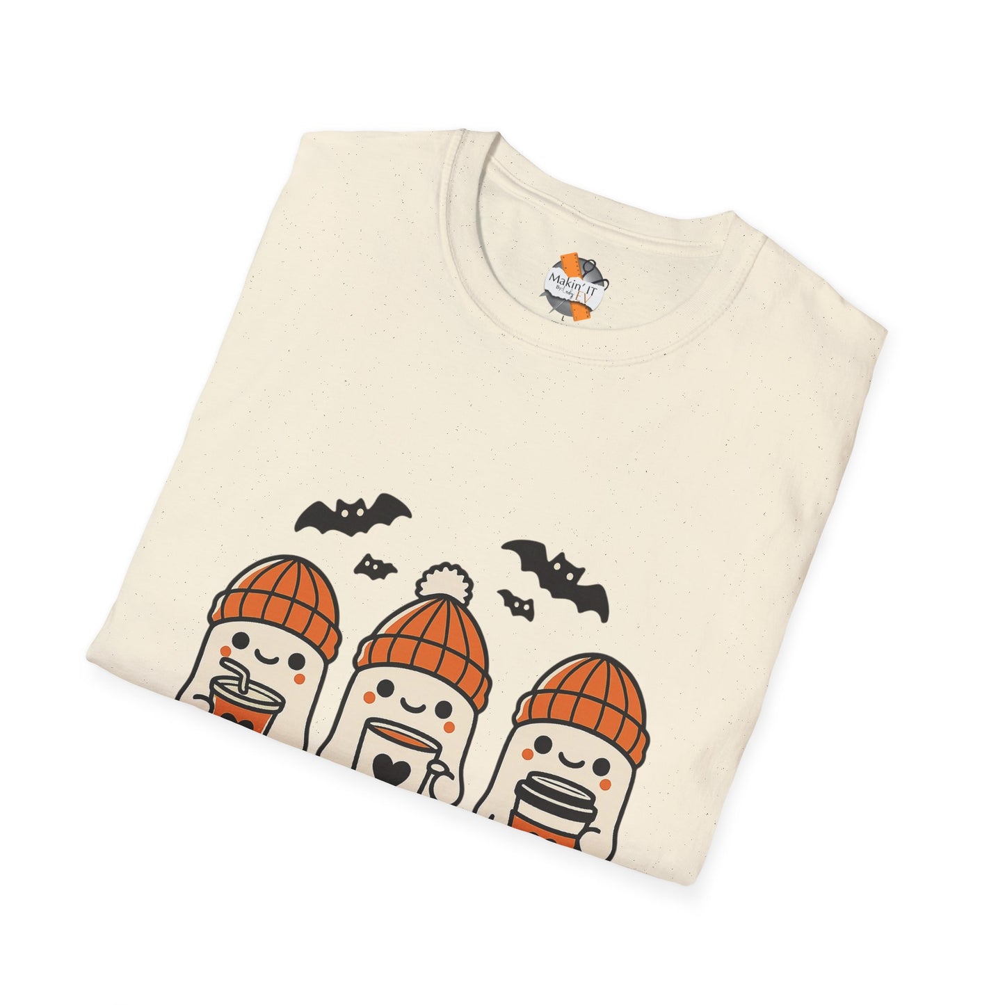 Folded oatmeal Halloween t-shirt with ghost trio wearing orange beanies holding drinks, Makin’ It By Lady Ev