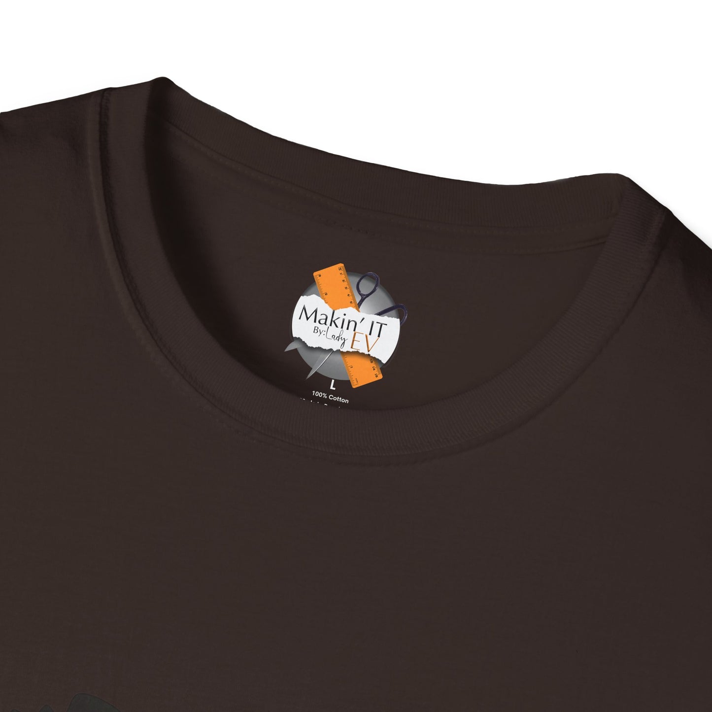 Close-up of brown cotton t-shirt collar with Makin’ It By Lady Ev custom neck tag and size label.