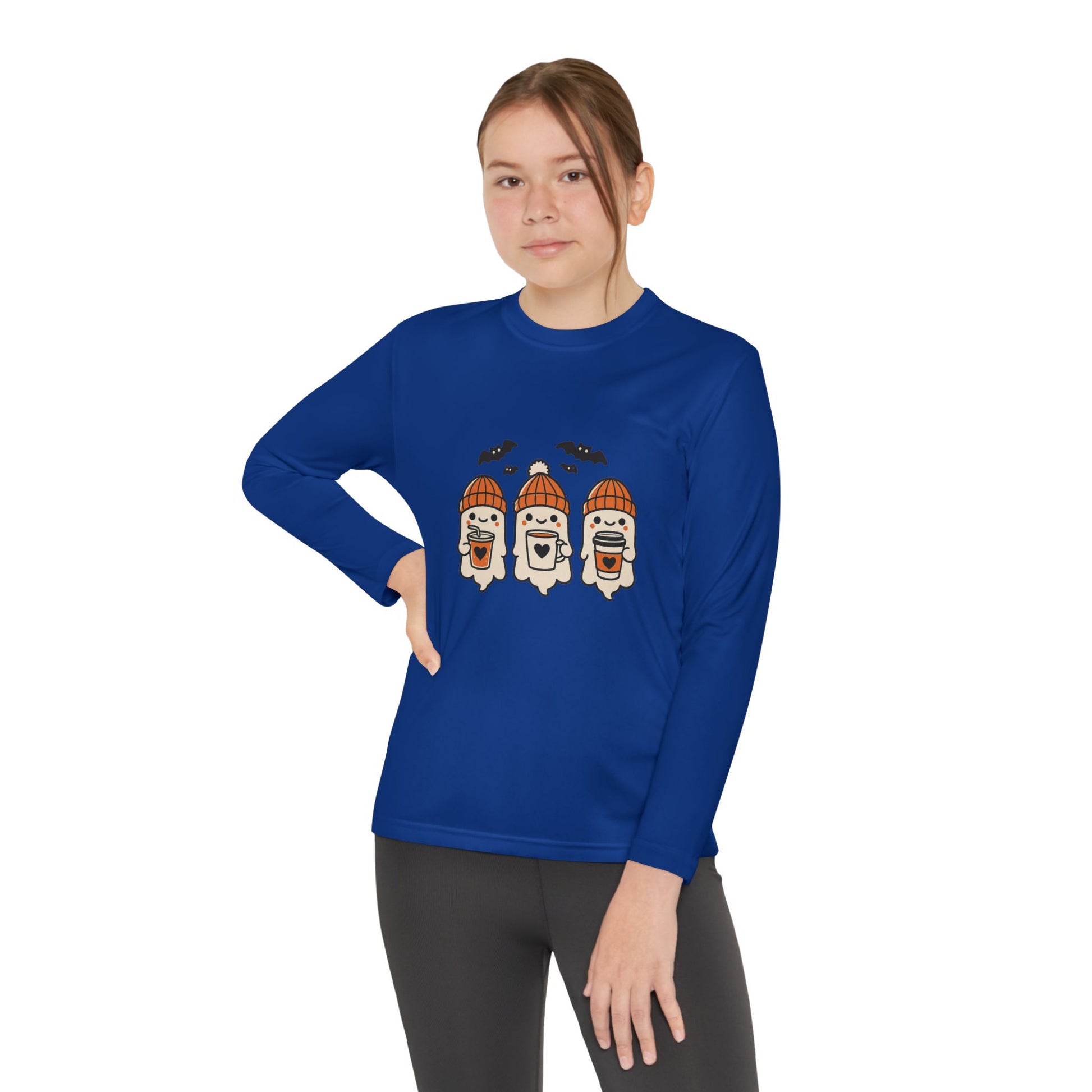 young girl wearing royal blue long sleeve Halloween shirt featuring three smiling ghosts in orange beanies holding coffee mugs with bats flying overhead.