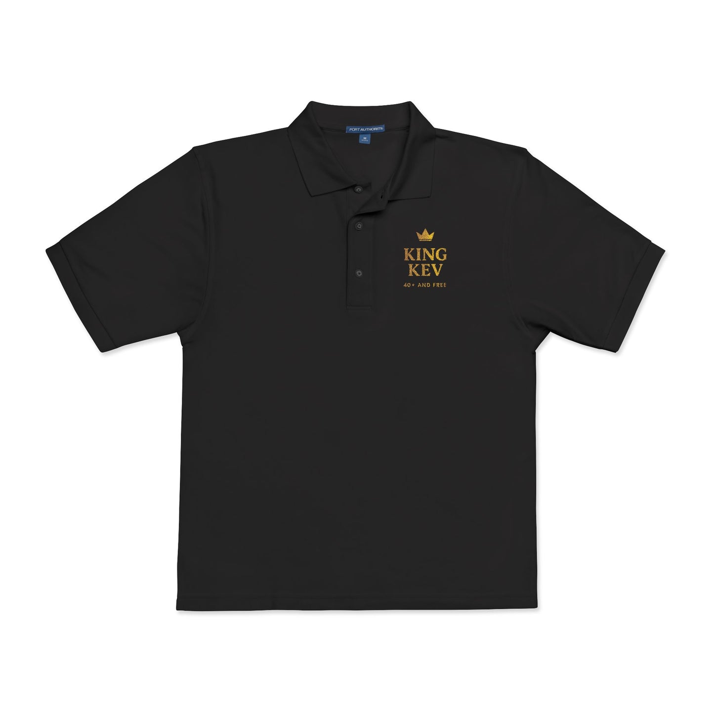 Black polo shirt flat lay with King Kev 40+ And Free logo in gold on left chest – Makin’ It By Lady Ev.