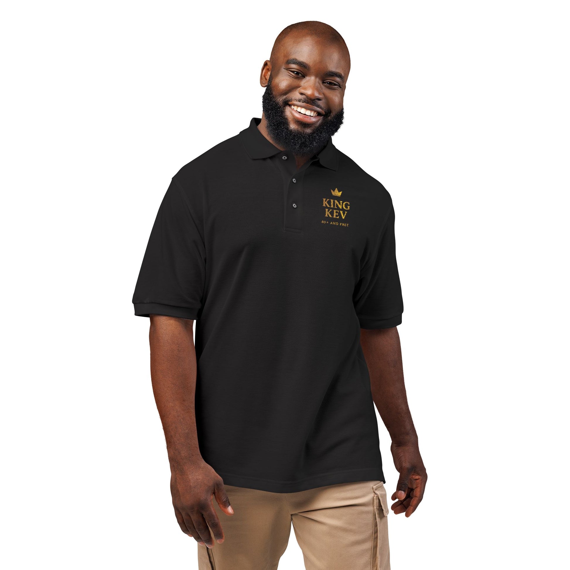 Smiling male model wearing black polo shirt with gold King Kev 40+ And Free chest logo – Makin’ It By Lady Ev.