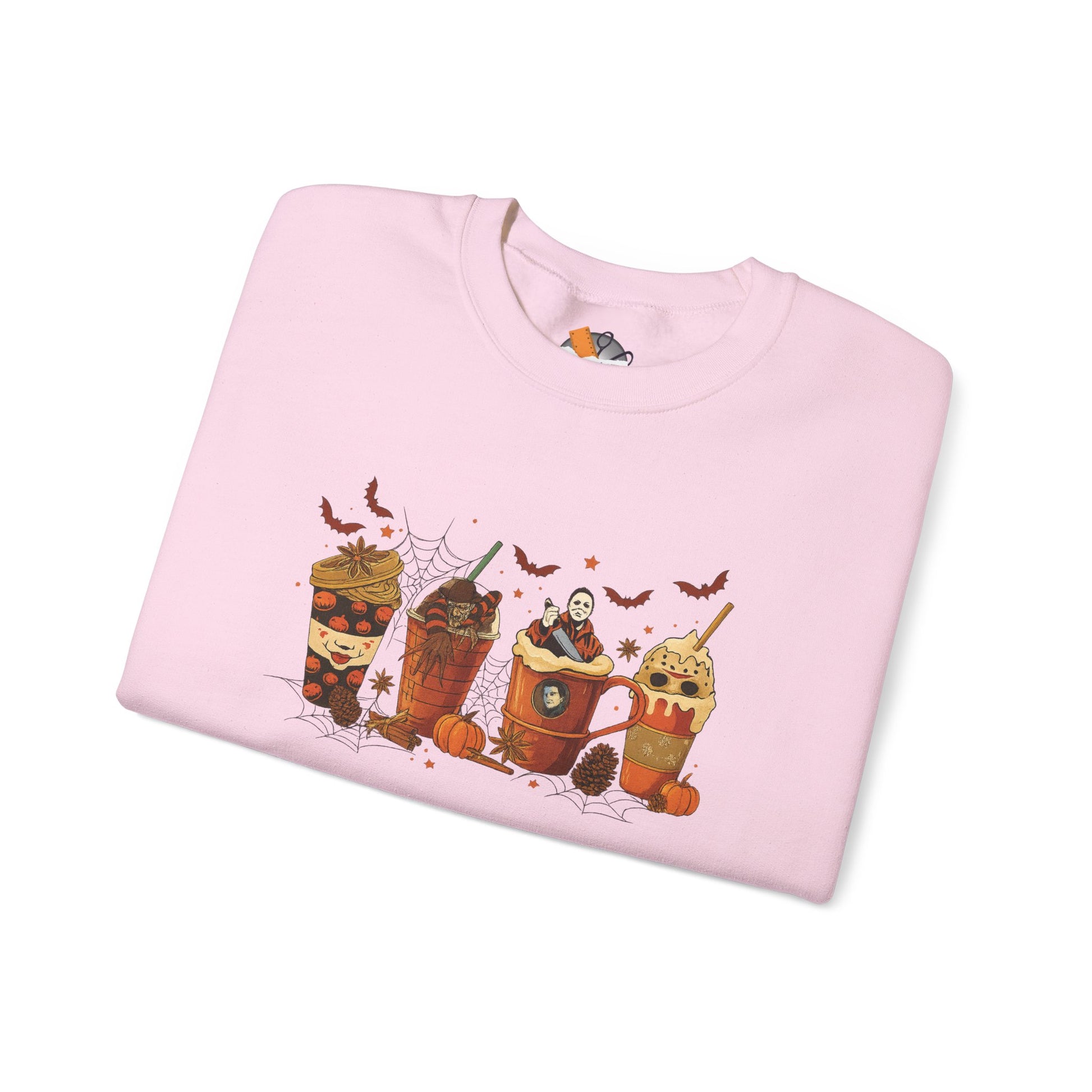 Folded light pink Gildan 18000 crewneck sweatshirt with Halloween horror coffee drinks graphic featuring spooky characters and pumpkins.