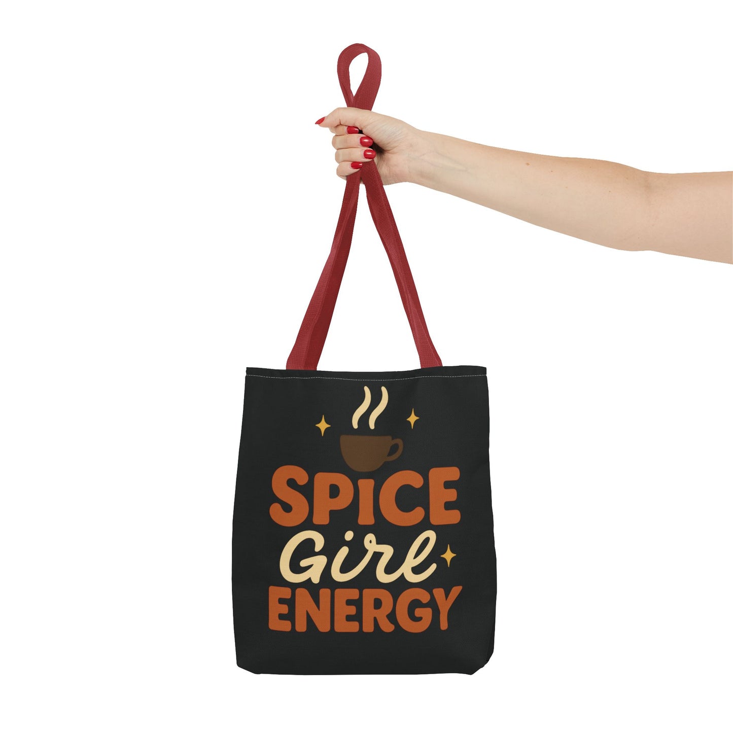 Red-handled black “Spice Girl Energy” tote bag held in hand — bold autumn tote for coffee lovers and everyday errands.