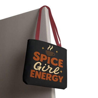 Black “Spice Girl Energy” tote bag with red straps hanging on wall — trendy fall accessory for pumpkin spice and coffee fans.