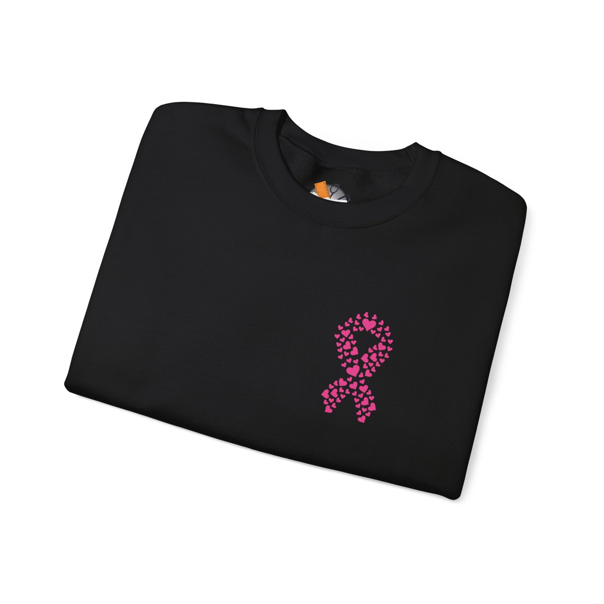 Folded black crewneck sweatshirt with pink ribbon of hearts design promoting breast cancer awareness, Makin’ It by Lady Ev.