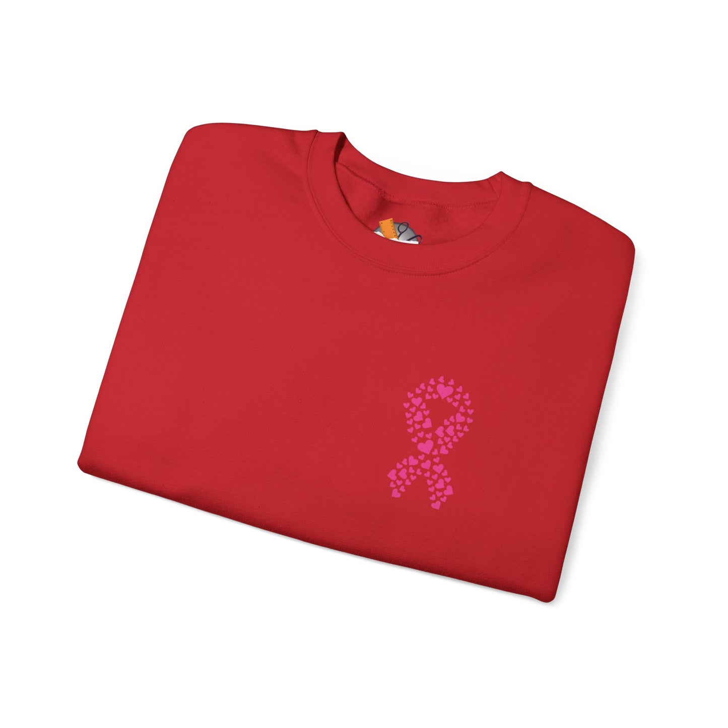 Folded red crewneck sweatshirt featuring pink ribbon made of hearts for breast cancer awareness, Makin’ It by Lady Ev