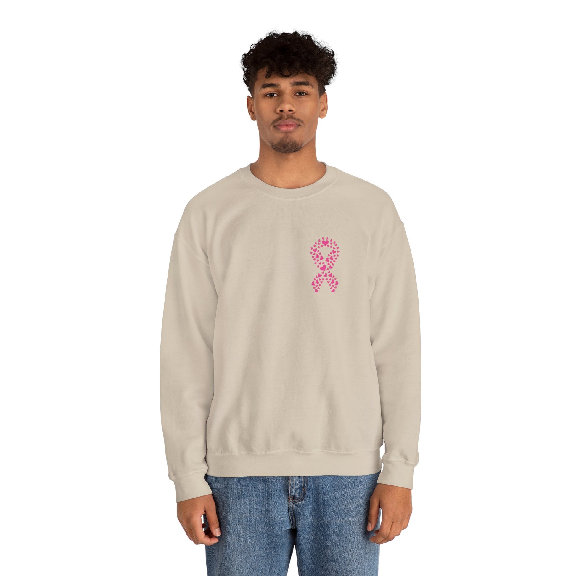 Man wearing sand-colored breast cancer awareness crewneck sweatshirt featuring pink ribbon made of hearts, Makin’ It by Lady Ev.