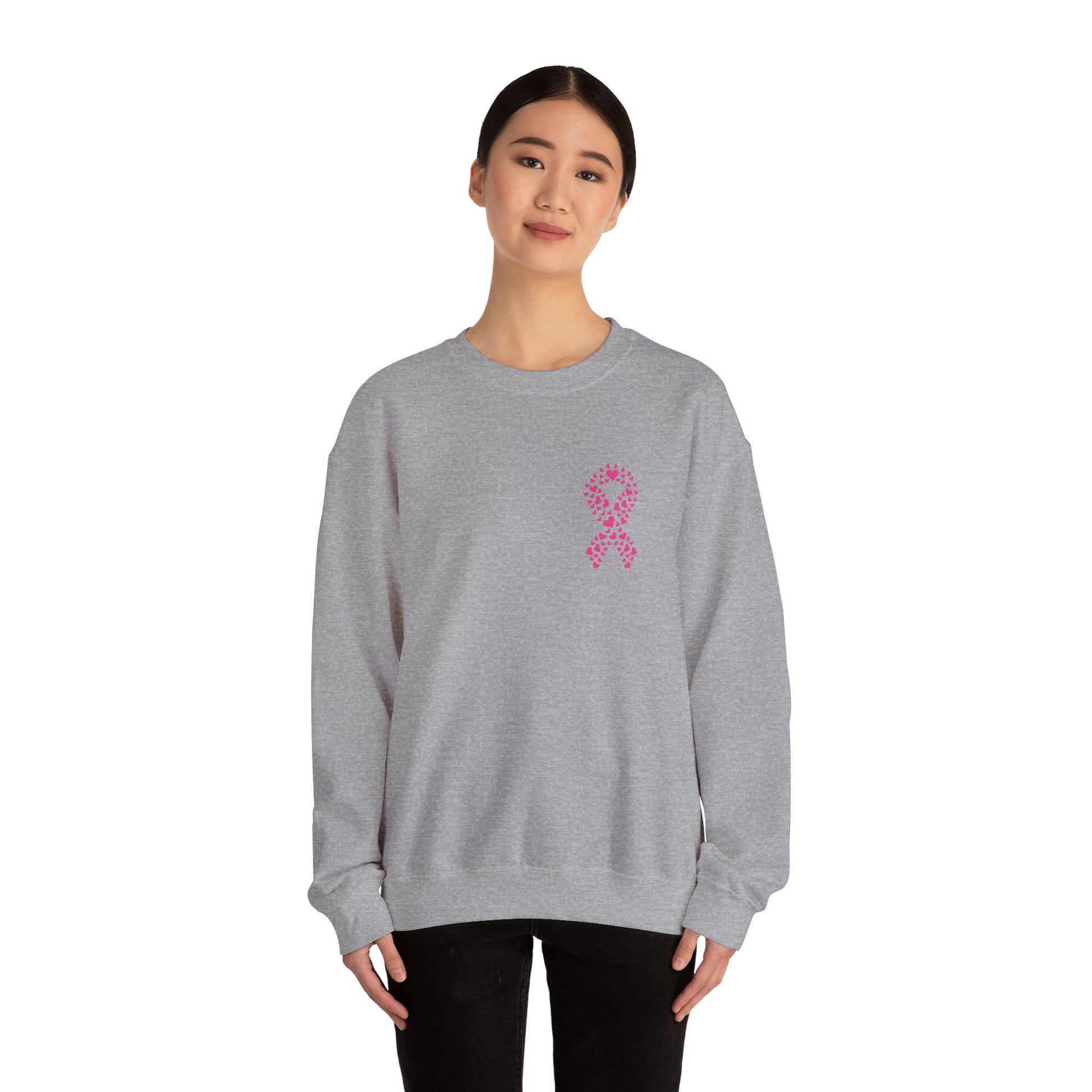Woman wearing sport gray breast cancer awareness crewneck sweatshirt featuring pink ribbon made of hearts, Makin’ It by Lady Ev.