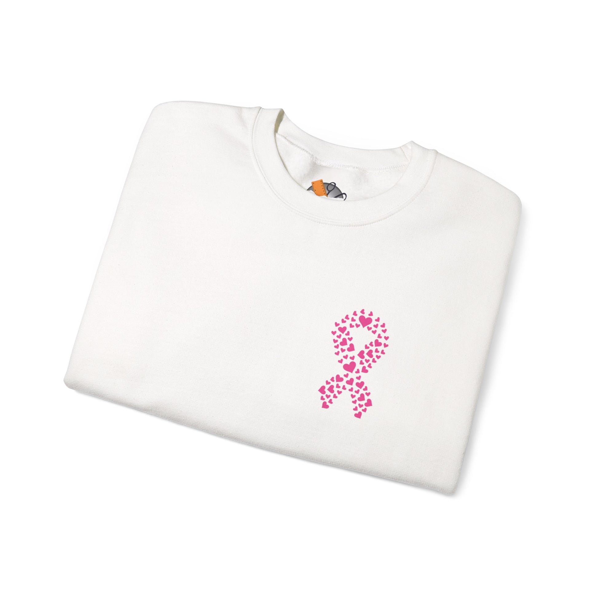 Folded white crewneck sweatshirt featuring pink heart-shaped ribbon design for breast cancer awareness, Makin’ It by Lady Ev.