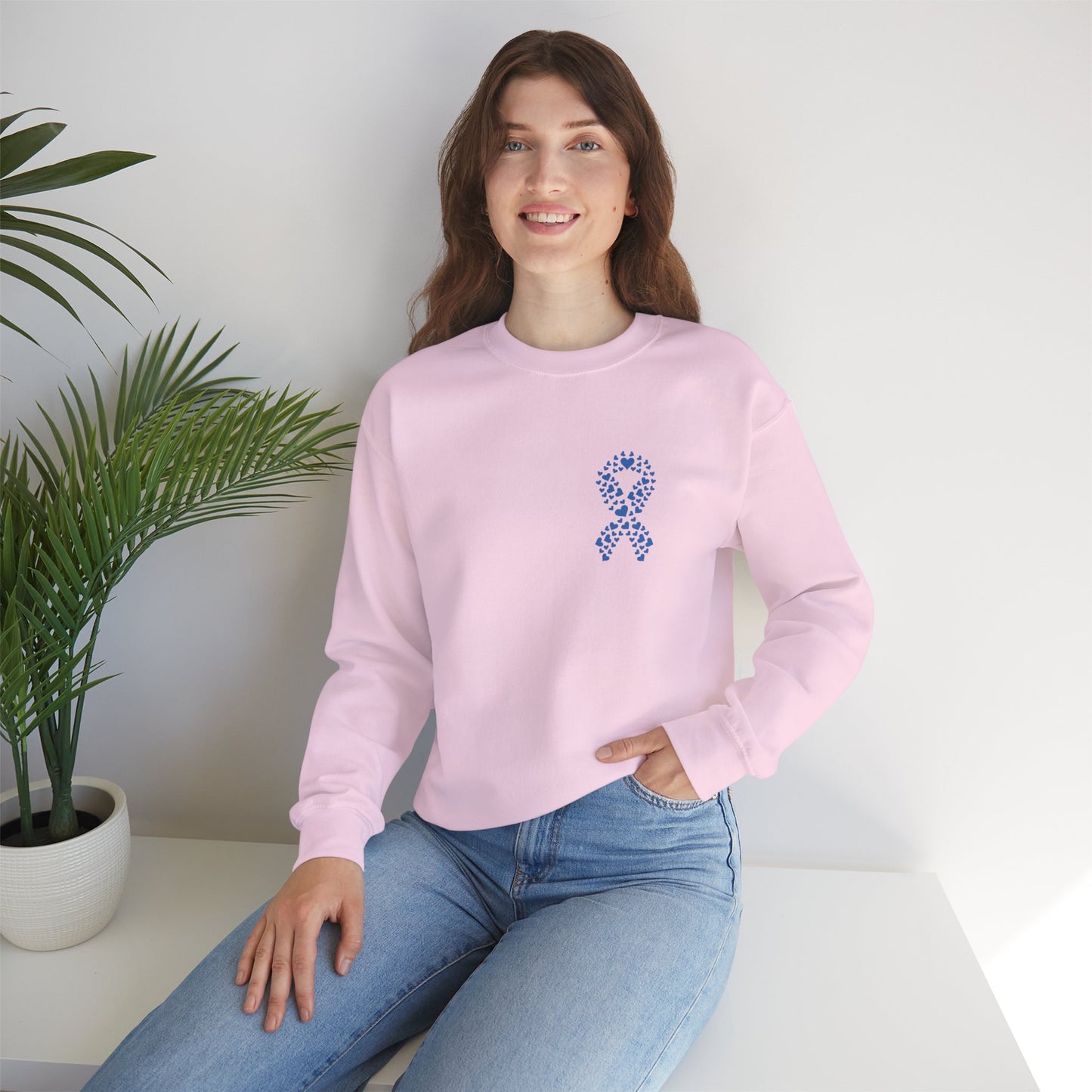 Smiling woman wearing light pink diabetes awareness crewneck indoors — casual, comfortable sweatshirt supporting diabetes awareness.