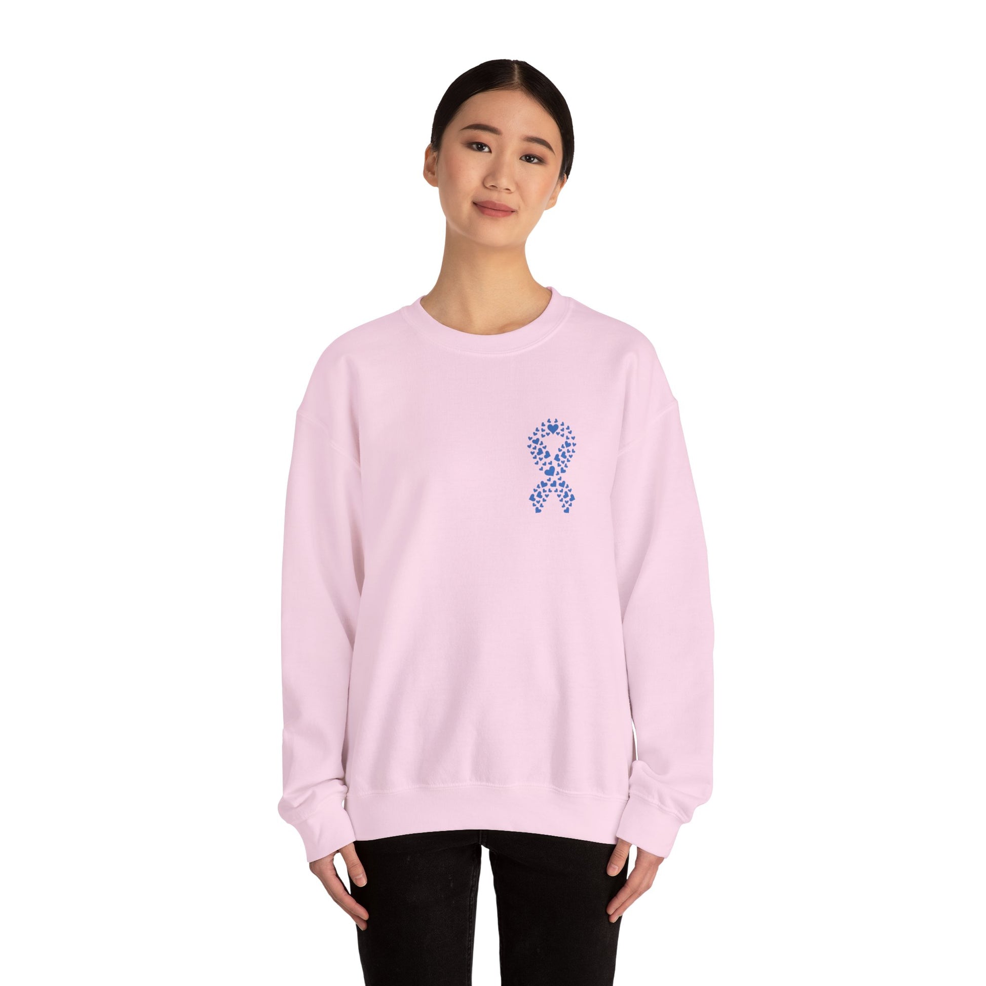 Woman wearing light pink diabetes awareness crewneck sweatshirt with blue heart ribbon — soft, stylish, and supportive apparel.