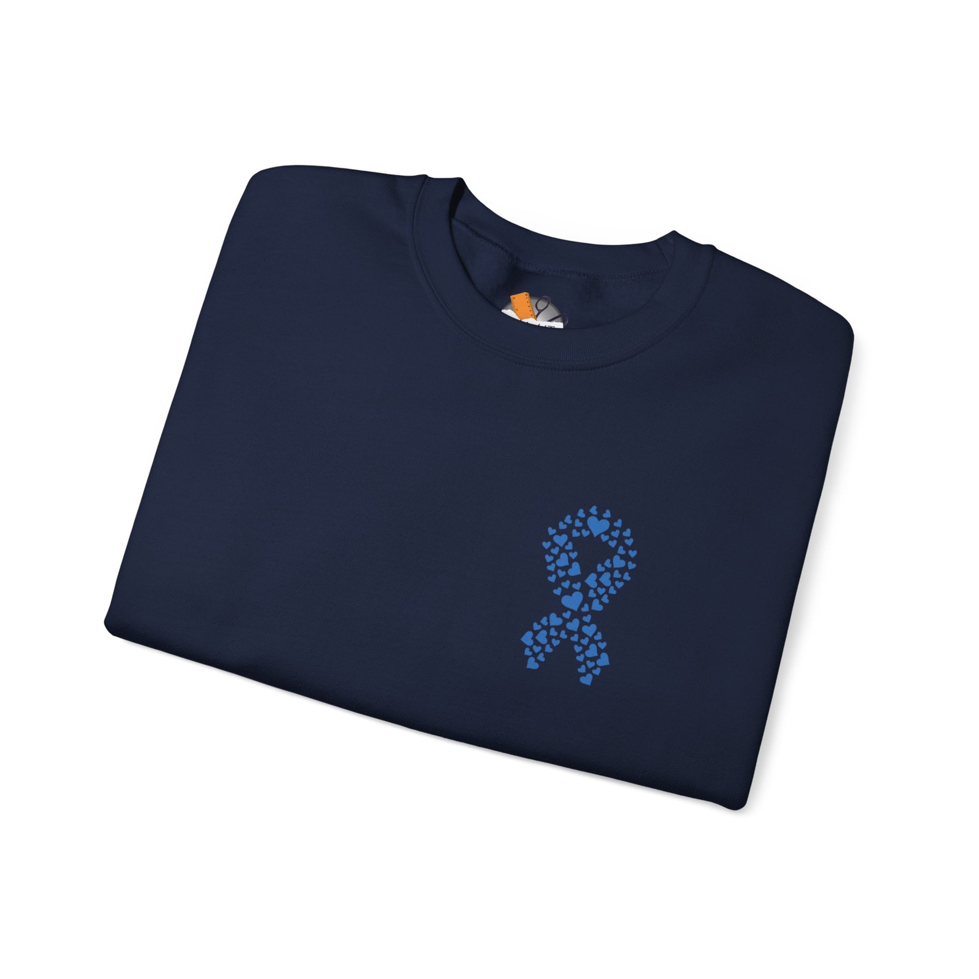 Folded navy blue diabetes awareness sweatshirt with blue heart ribbon — cozy unisex crewneck for awareness and compassion.