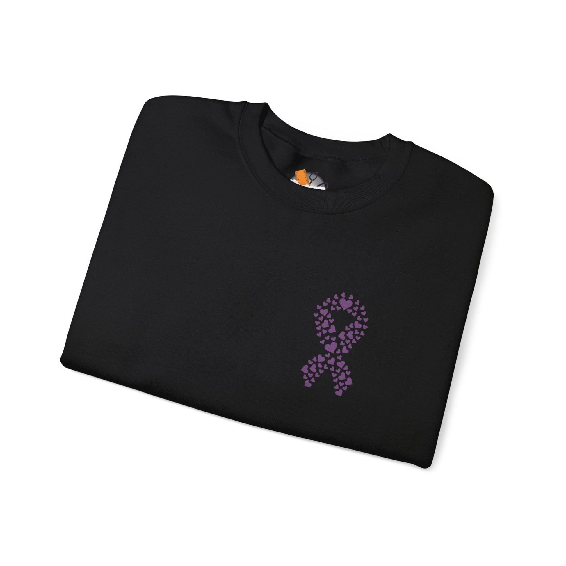 Folded black crewneck sweatshirt featuring purple ribbon made of hearts for domestic violence awareness, Makin’ It by Lady Ev.
