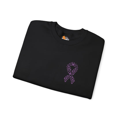 Folded black crewneck sweatshirt featuring purple ribbon made of hearts for domestic violence awareness, Makin’ It by Lady Ev.