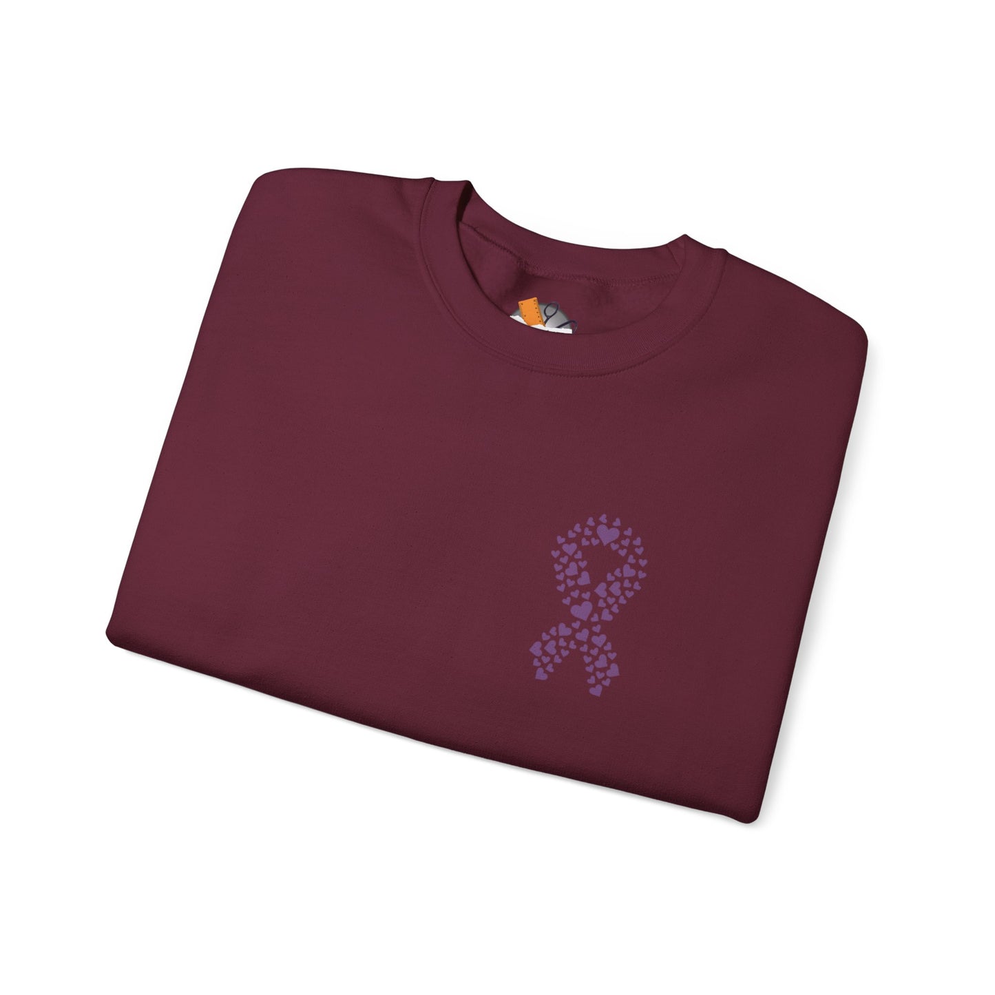 Folded maroon crewneck sweatshirt featuring purple ribbon of hearts design supporting domestic violence awareness, Makin’ It by Lady Ev.