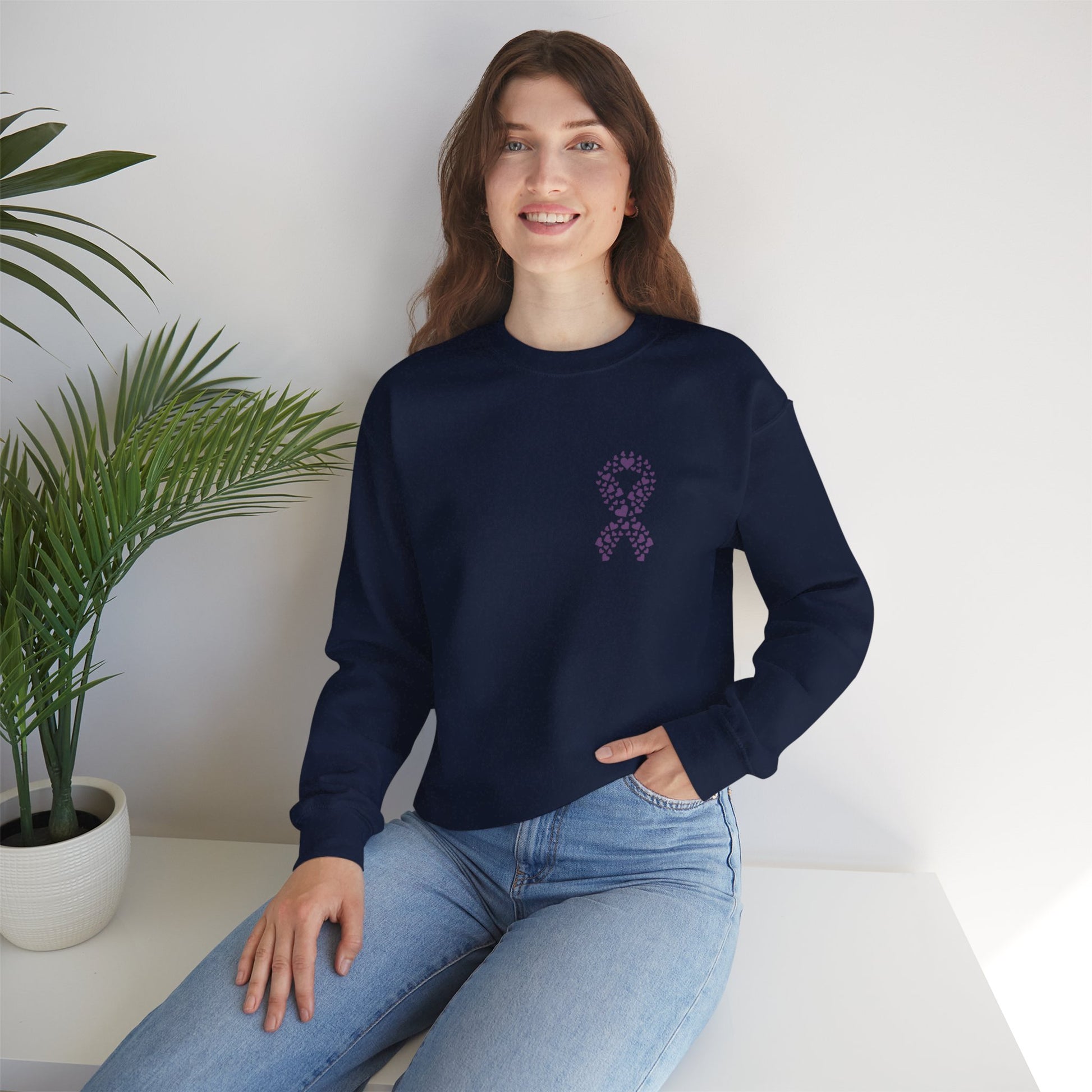 Woman seated in navy blue domestic violence awareness crewneck sweatshirt with purple heart ribbon design, Makin’ It by Lady Ev.