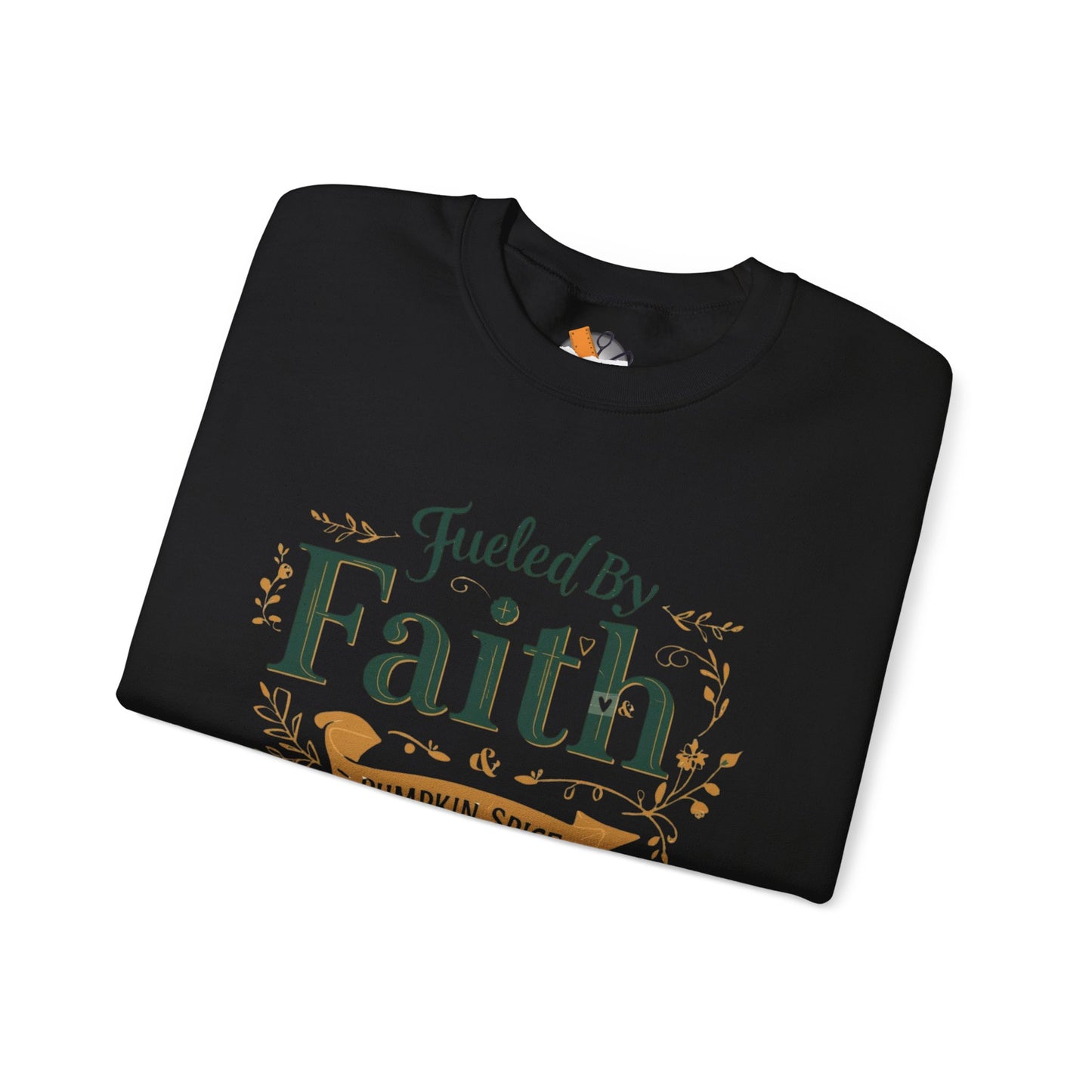 Folded black “Fueled by Faith & Pumpkin Spice” sweatshirt with gold and green design — minimalist Christian fall apparel flat lay.