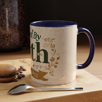 Lifestyle photo of navy “Fueled by Faith & Pumpkin Spice” 11oz accent mug — Christian fall coffee mug beside dessert, coffee beans, and spoon on wooden table.