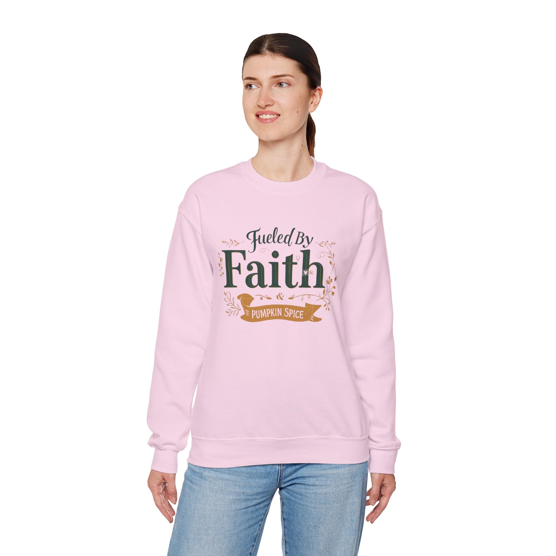 Woman modeling light pink “Fueled by Faith & Pumpkin Spice” sweatshirt — soft cozy unisex Christian crewneck for fall.