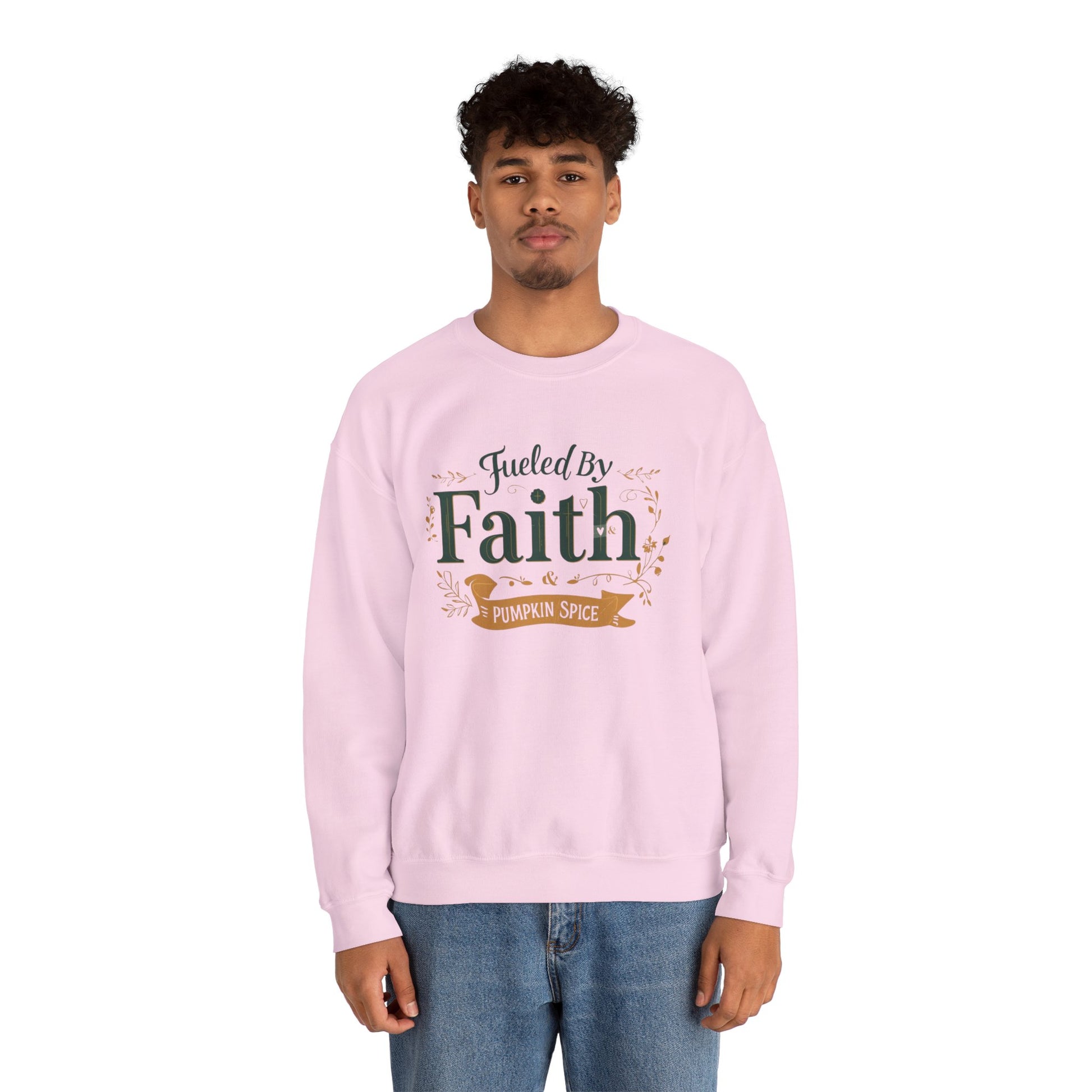 Man wearing light pink “Fueled by Faith & Pumpkin Spice” crewneck sweatshirt — casual unisex Christian fall outfit.