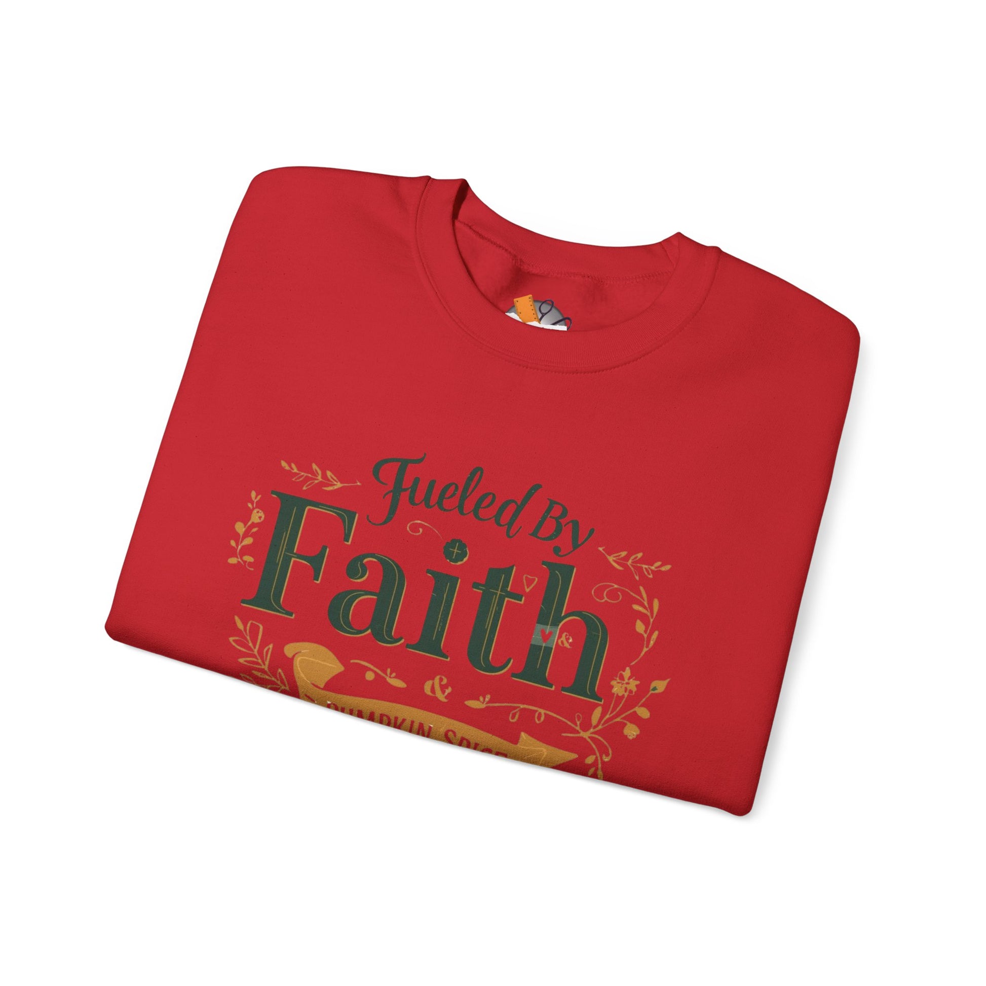 Folded red “Fueled by Faith & Pumpkin Spice” sweatshirt with gold and green typography — cozy autumn flat lay mockup.