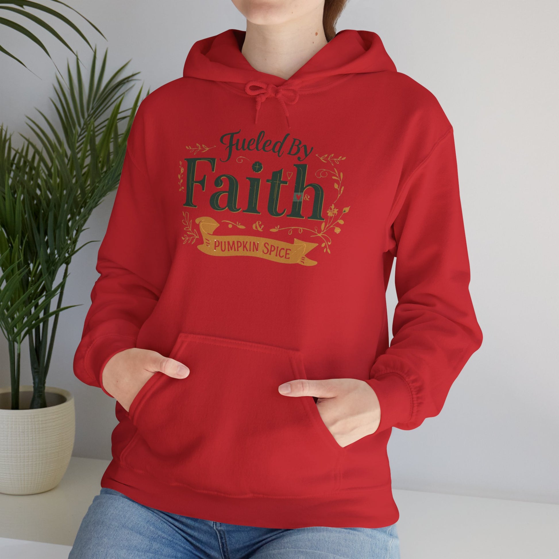 Cozy fall lifestyle photo of red “Fueled by Faith & Pumpkin Spice” hoodie — Christian apparel for pumpkin spice season.