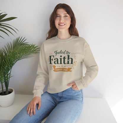Woman sitting comfortably in sand “Fueled by Faith & Pumpkin Spice” sweatshirt — cozy fall Christian lifestyle apparel photo.