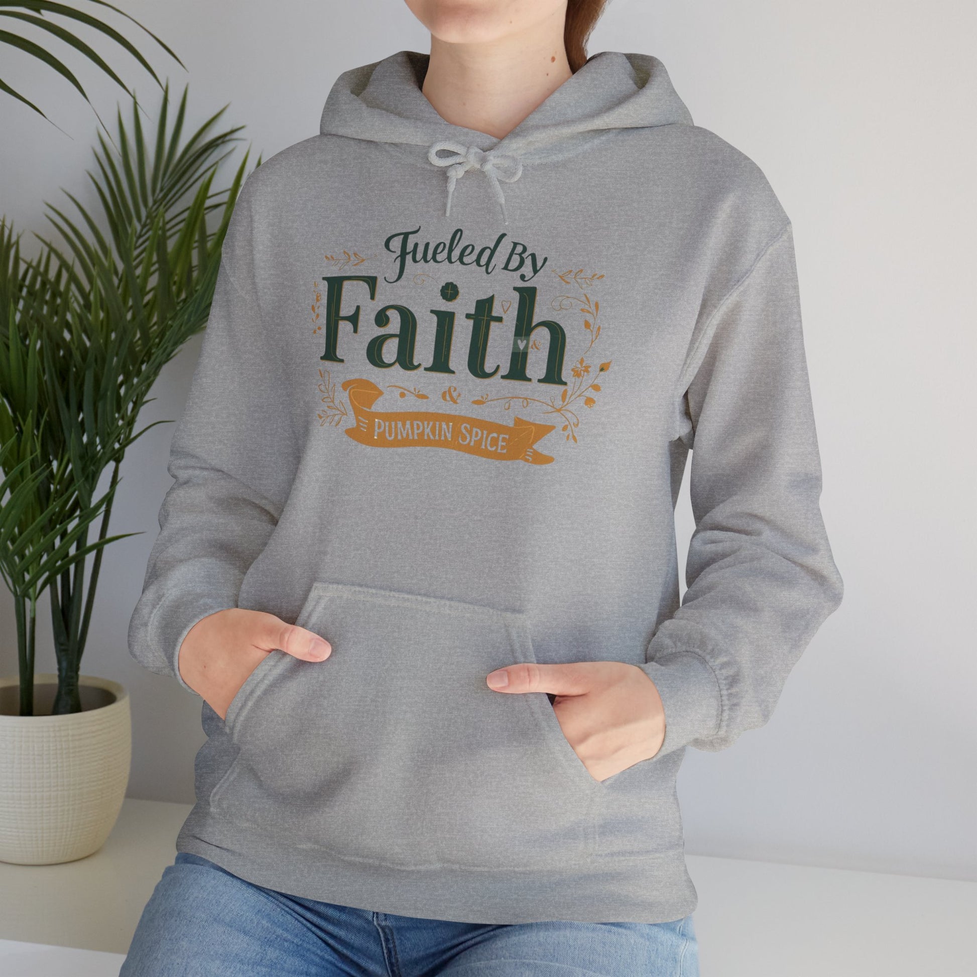 Lifestyle image of sport grey “Fueled by Faith & Pumpkin Spice” hoodie — Christian fall apparel perfect for cozy mornings.