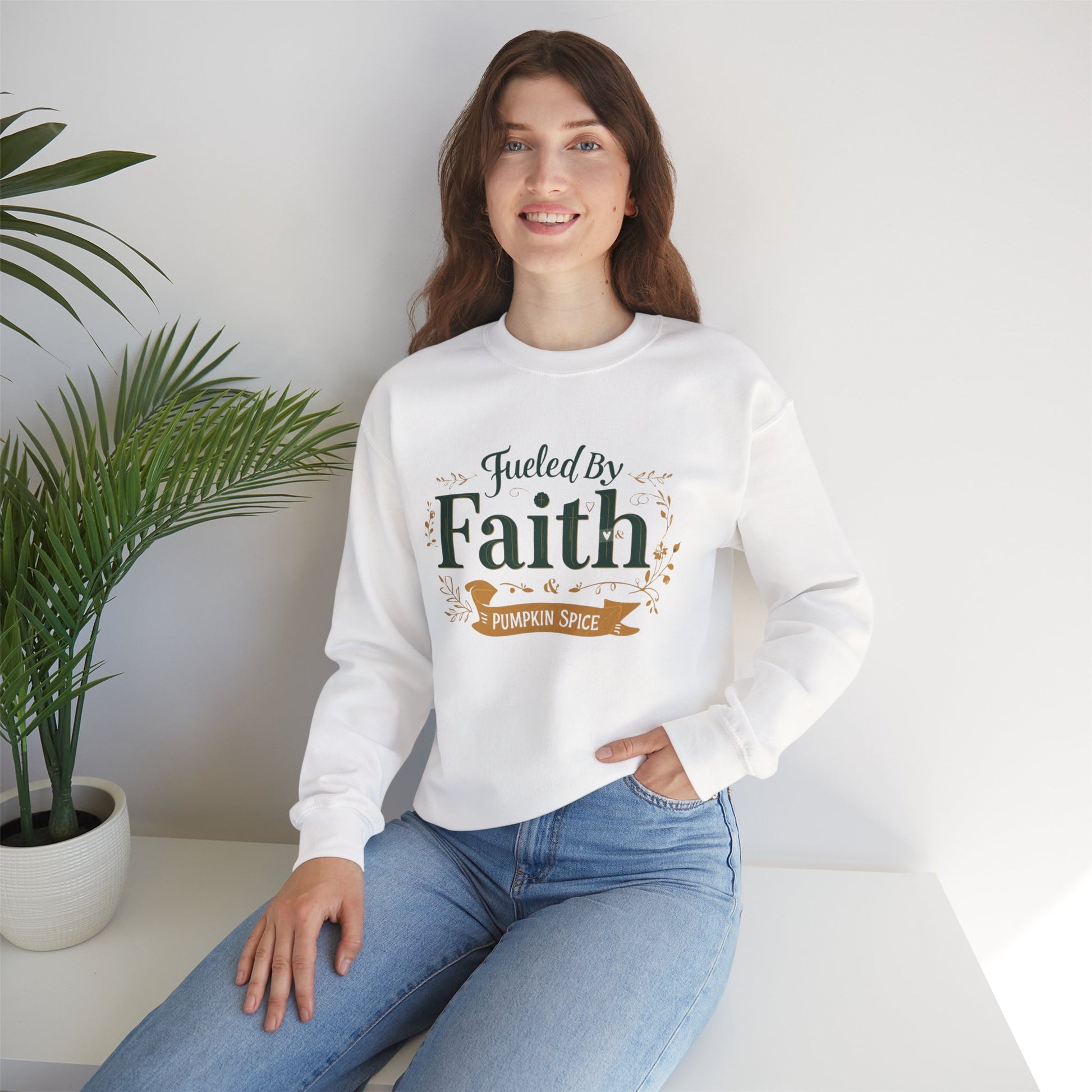 Woman sitting in white “Fueled by Faith & Pumpkin Spice” sweatshirt — cozy Christian lifestyle apparel for fall inspiration.