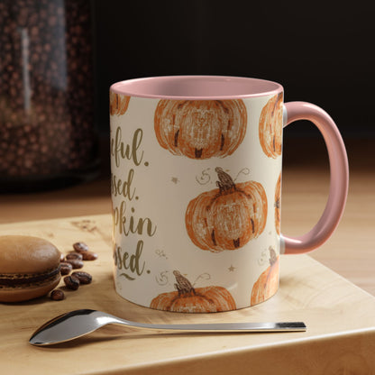 Grateful, Blessed & Pumpkin Obsessed light pink accent mug styled on wooden coffee bar with macaron and spoon — cozy autumn morning setup.