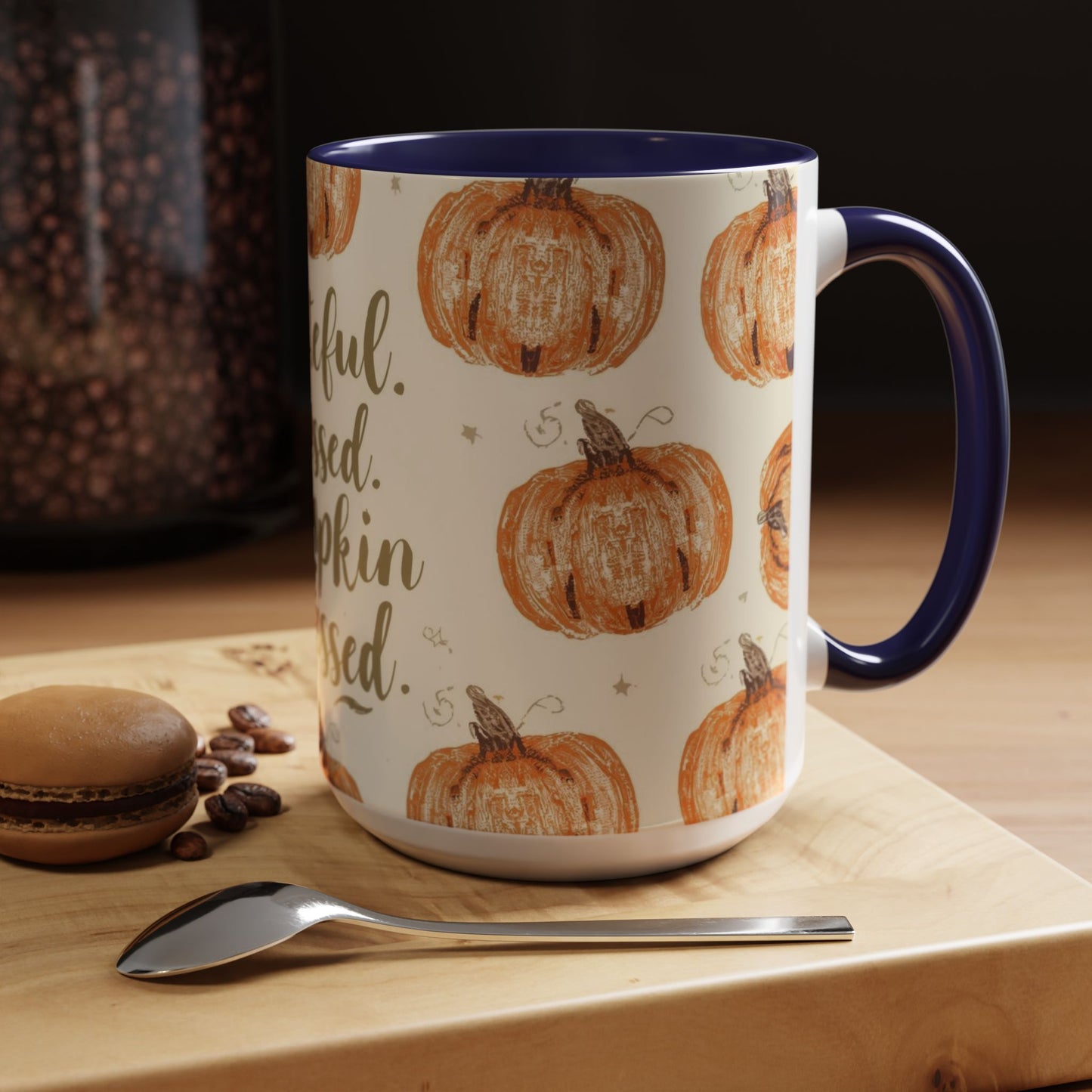 Grateful, Blessed & Pumpkin Obsessed navy accent mug on wooden table — cozy fall coffee setup with macaron, spoon, and warm morning light.