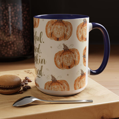 Grateful, Blessed & Pumpkin Obsessed navy accent mug on wooden table — cozy fall coffee setup with macaron, spoon, and warm morning light.