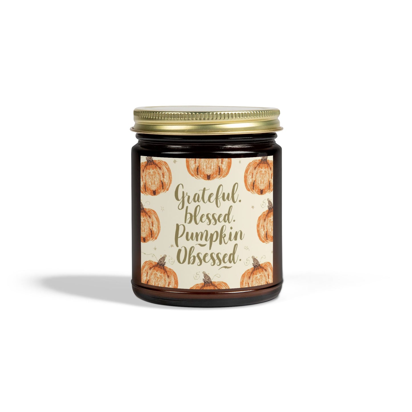 Amber glass “Grateful, Blessed & Pumpkin Obsessed” 9oz candle with gold lid — fall pumpkin label and cozy cashmere musk scent for warm home decor.