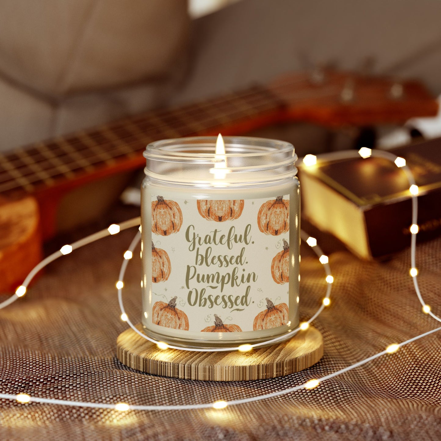 “Grateful, Blessed & Pumpkin Obsessed” clear jar candle surrounded by warm fairy lights — cozy fall decor and relaxing cashmere musk fragrance.