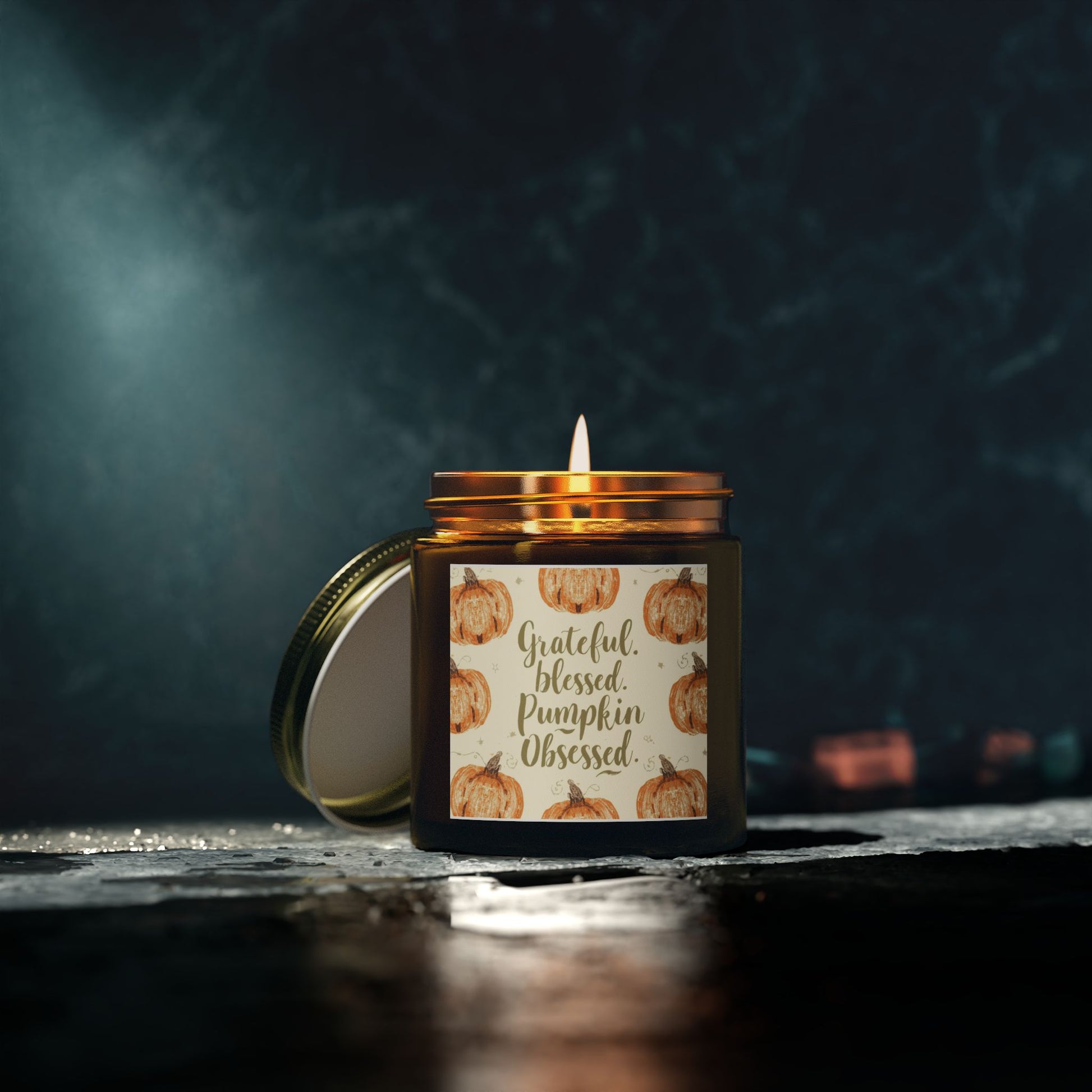 “Grateful, Blessed & Pumpkin Obsessed” amber candle glowing in dark setting — woodsy Fraser Fir scent with notes of pine, cedar, and crisp fall air.