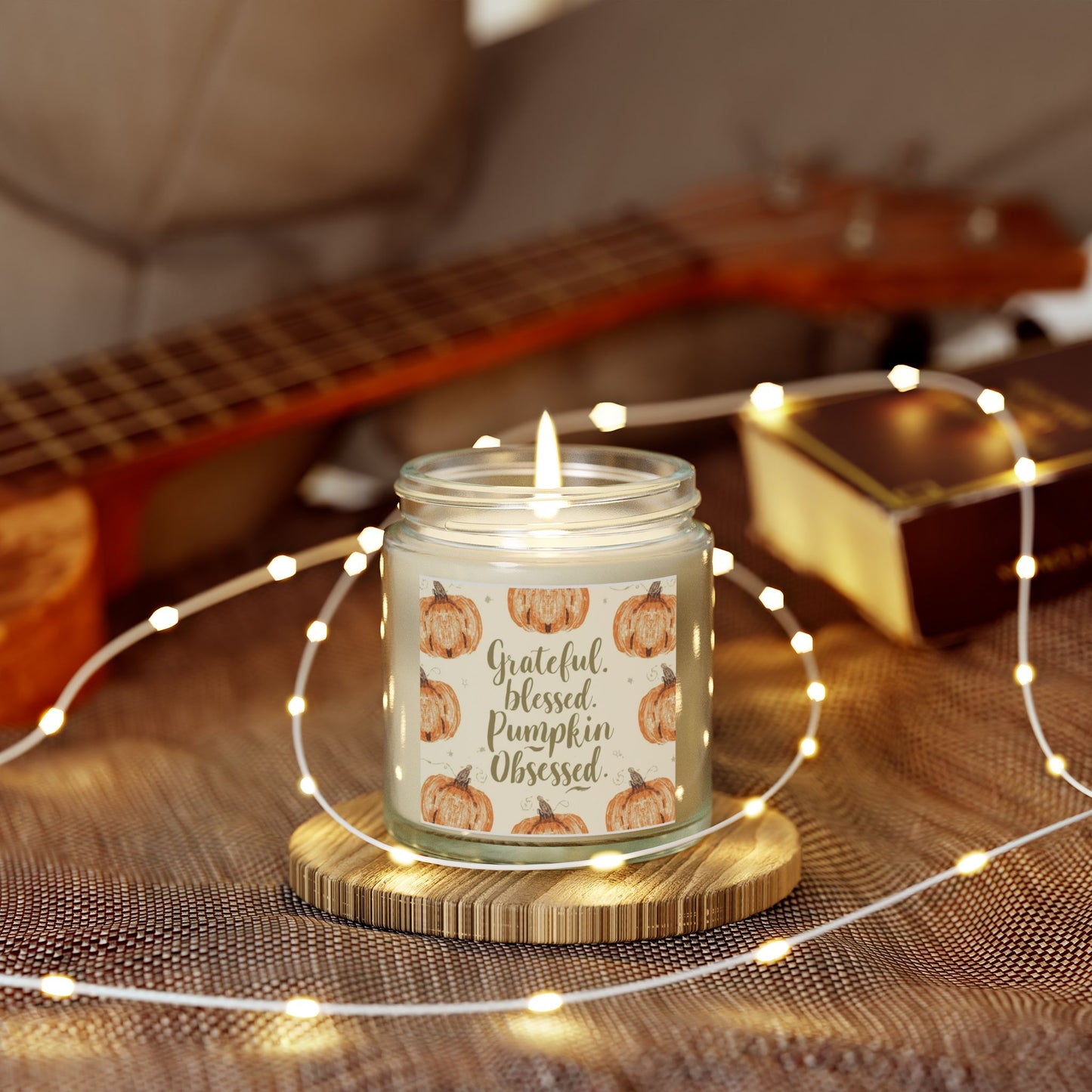 “Grateful, Blessed & Pumpkin Obsessed” clear candle surrounded by fairy lights — unscented soy candle with pumpkin design for cozy fall nights.