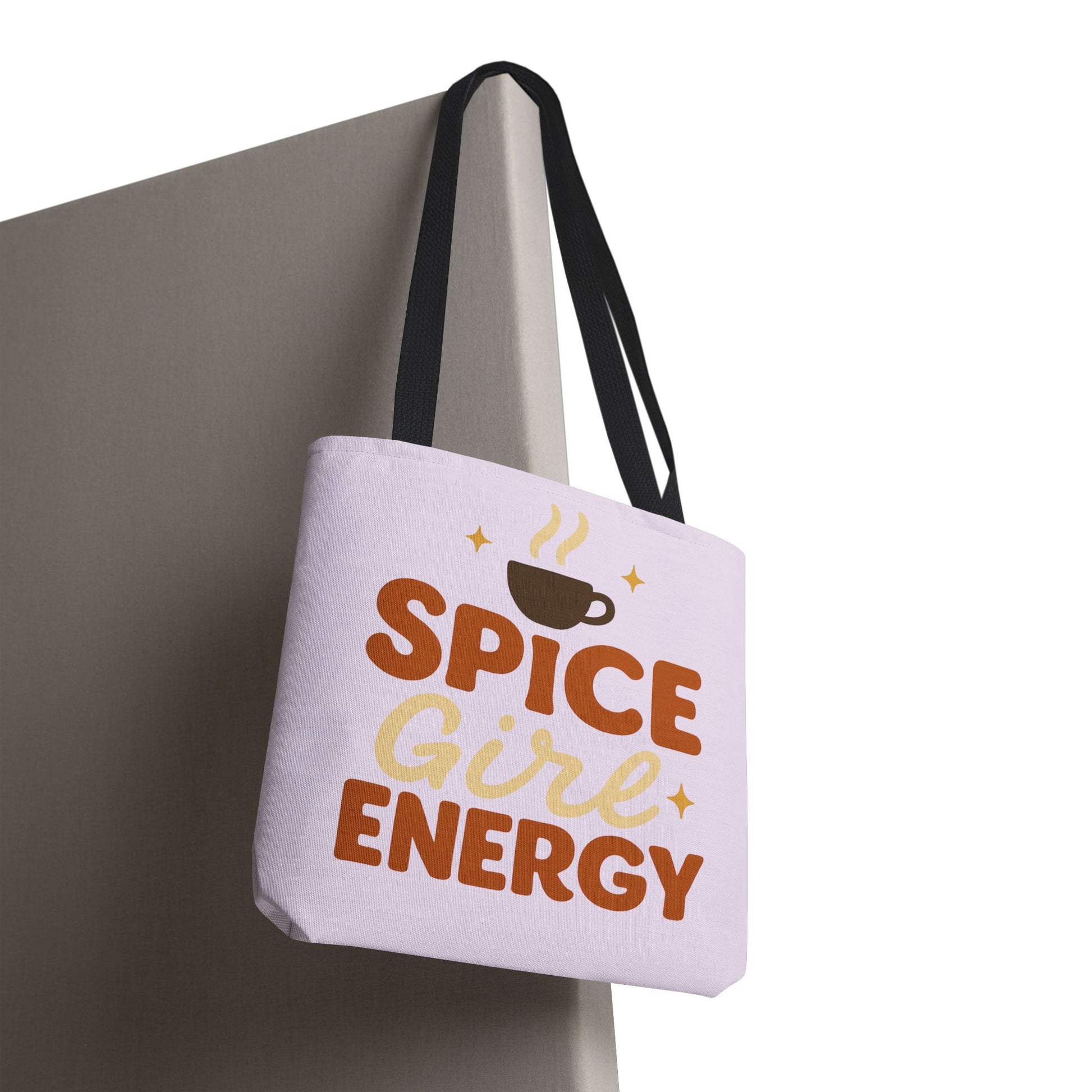 “Spice Girl Energy” tote bag with black straps hanging on wall — trendy lilac tote bag with coffee cup graphic for daily use or gifting.