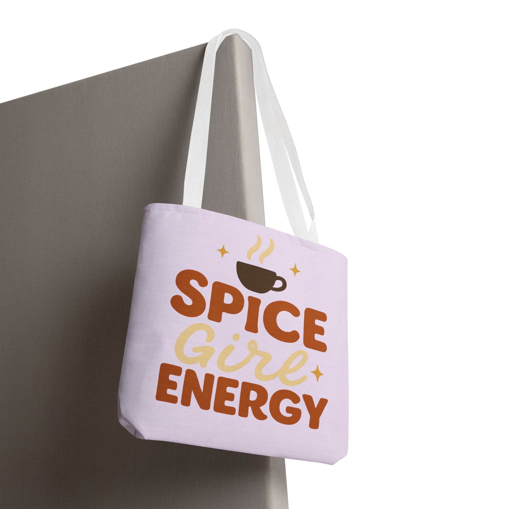 “Spice Girl Energy” tote bag in lilac with white straps hanging on surface — coffee-cup print tote bag perfect for gifts and fall aesthetic.