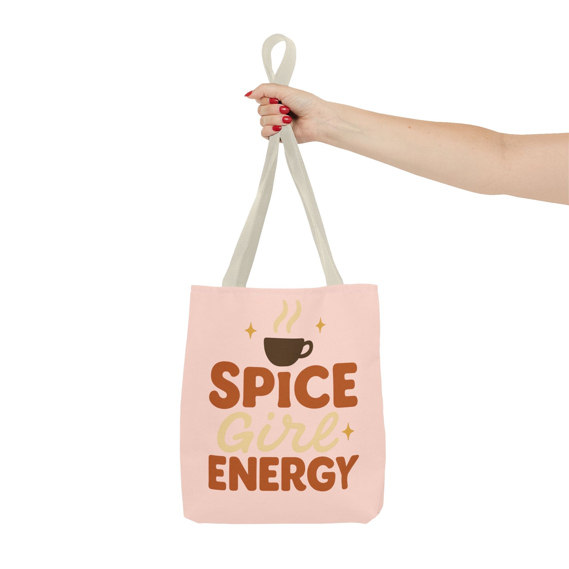 Beige-handled pale pink “Spice Girl Energy” tote bag held in hand — cute pastel coffee-lover tote perfect for autumn outfits.
