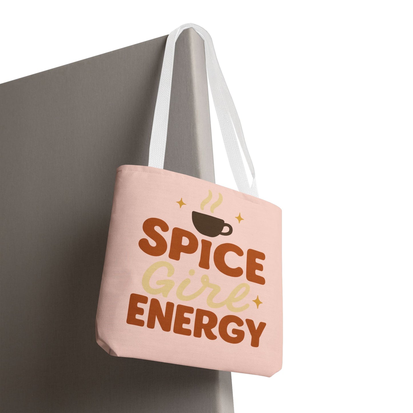 “Spice Girl Energy” tote bag in pale pink with white straps hanging — cute coffee-inspired tote bag for gifting and everyday errands.