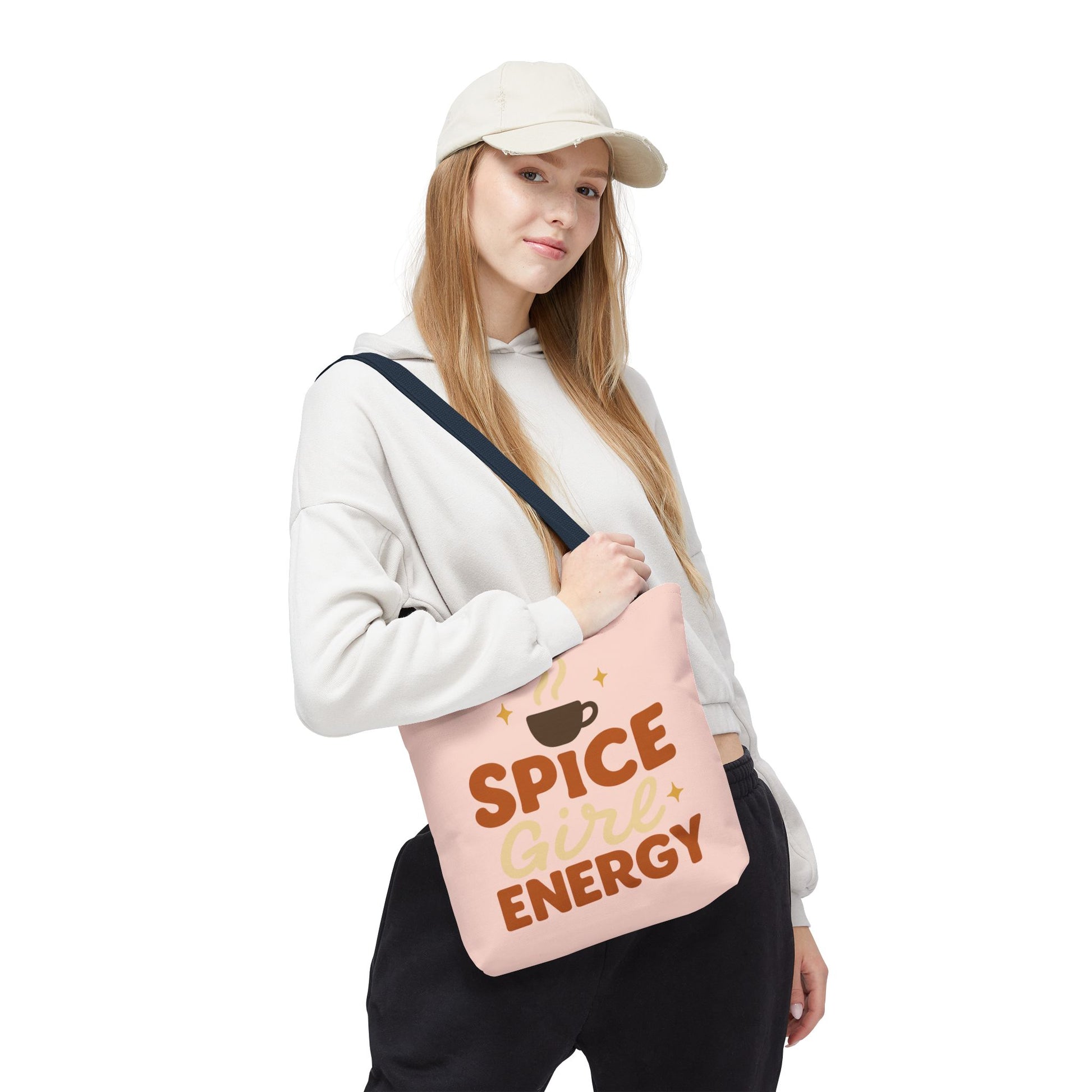 Model carrying pale pink “Spice Girl Energy” tote bag with navy handles — cute fall tote for coffee enthusiasts and everyday style.