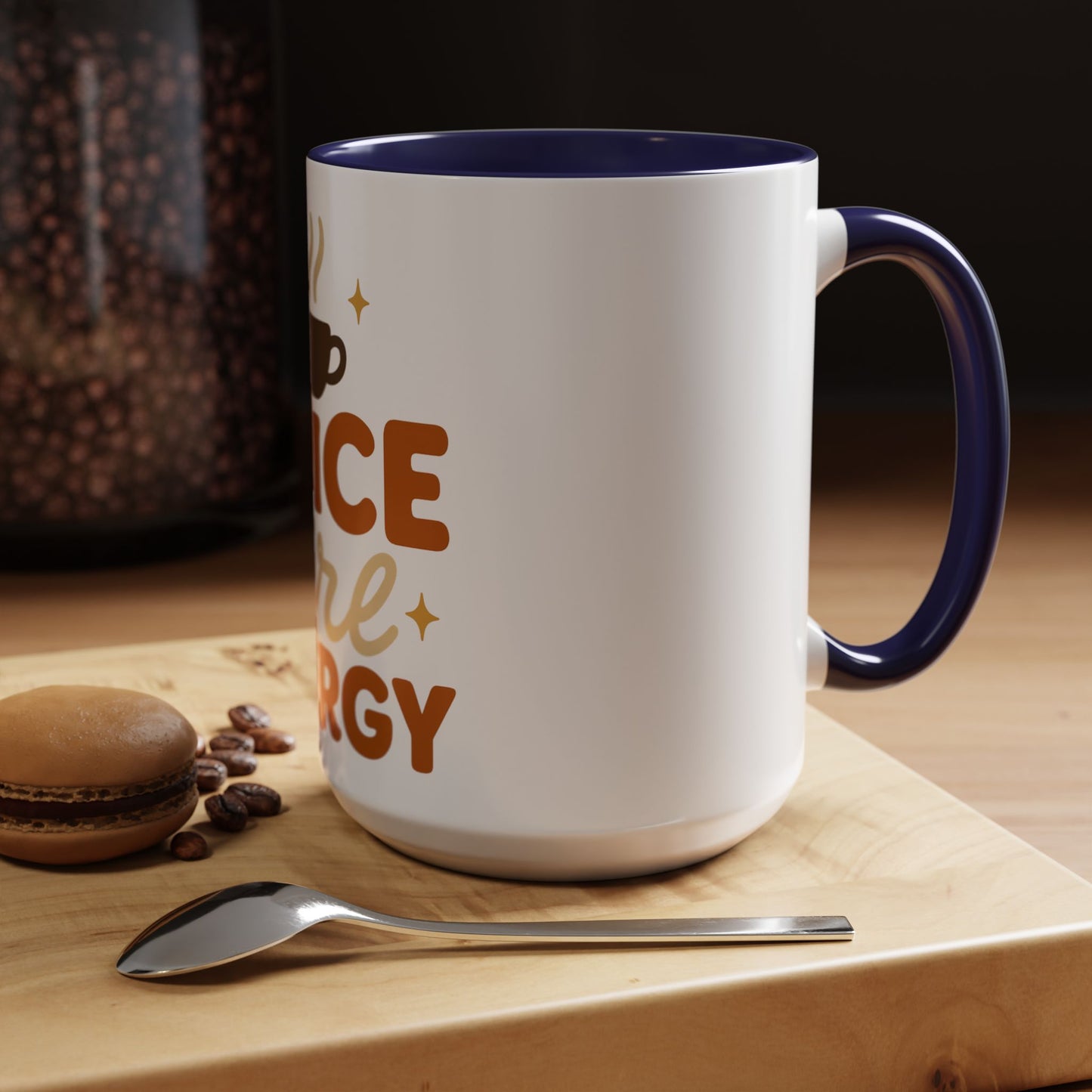 Navy “Spice Girl Energy” accent mug on wooden coffee table — white ceramic 15 oz mug with navy handle beside macaron and spoon for a cozy coffee moment.
