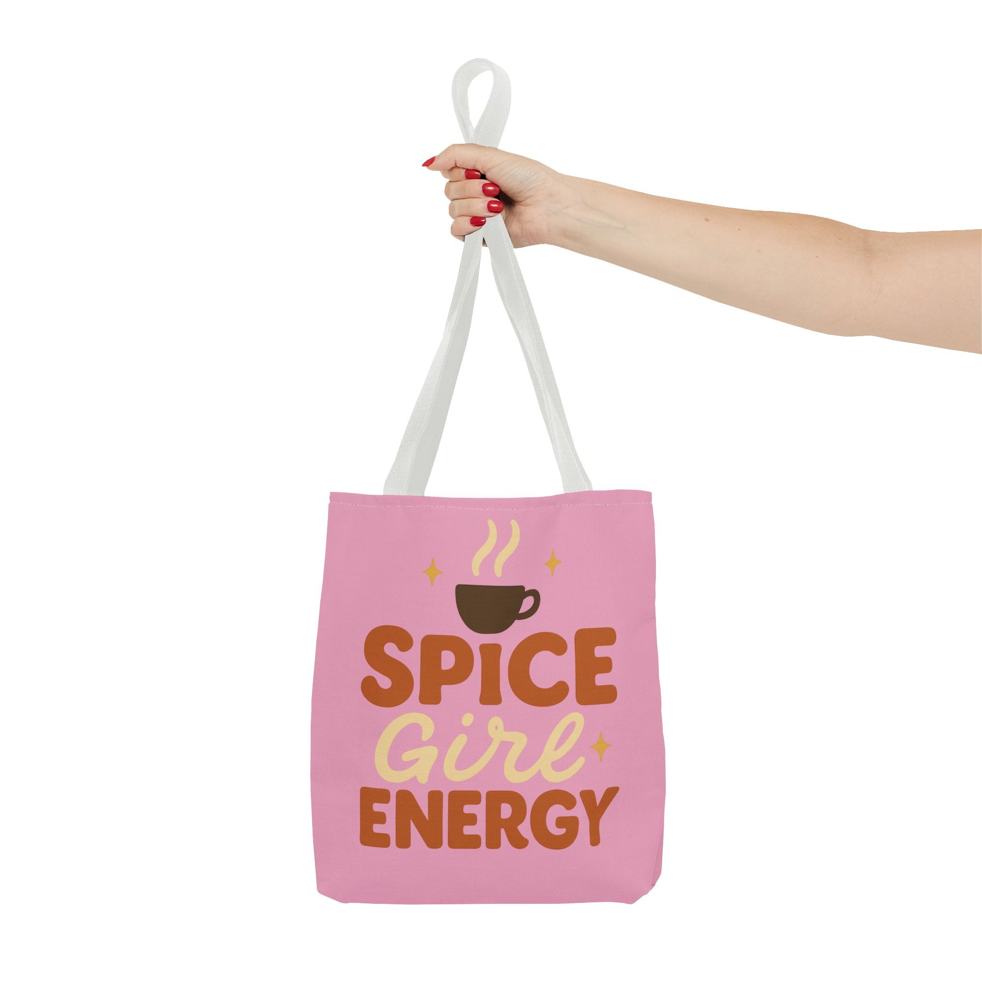 White-handled “Spice Girl Energy” tote bag held in hand — chic pink tote bag with coffee design for cozy autumn vibes.