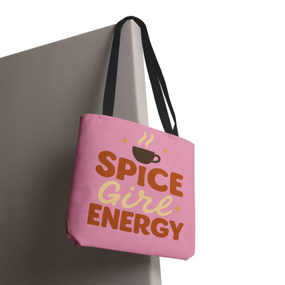 “Spice Girl Energy” tote bag with black straps hanging on wall — pink fall tote with coffee cup graphic and inspirational lettering.
