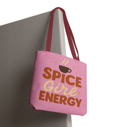 “Spice Girl Energy” tote bag with red straps hanging on wall — stylish pink tote bag for fall season and pumpkin spice lovers.