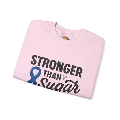 Folded pink Stronger Than Sugar crewneck sweatshirt with blue awareness ribbon design — cozy awareness apparel for diabetes support and community pride.
