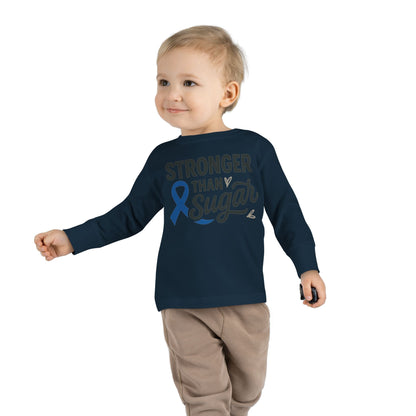 Toddler boy in navy Stronger Than Sugar long sleeve shirt — unisex awareness tee for children promoting diabetes education and hope.
