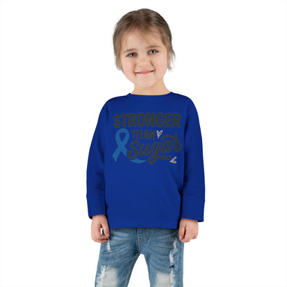 Toddler girl in royal blue Stronger Than Sugar shirt — unisex long sleeve for diabetes awareness, comfort, and motivation by Makin’ It By Lady Ev.