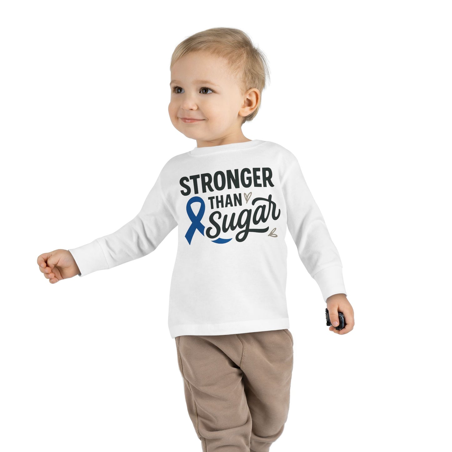 Toddler boy wearing white Stronger Than Sugar long sleeve shirt — kids awareness top with blue diabetes ribbon symbolizing health and resilience.